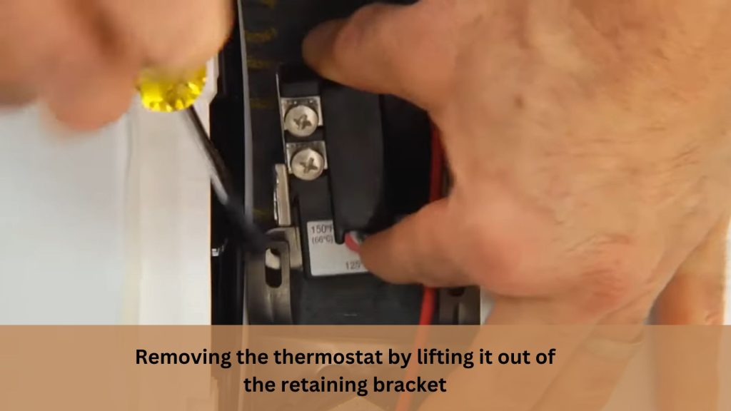 Removing the thermostat by lifting it out of the retaining bracket